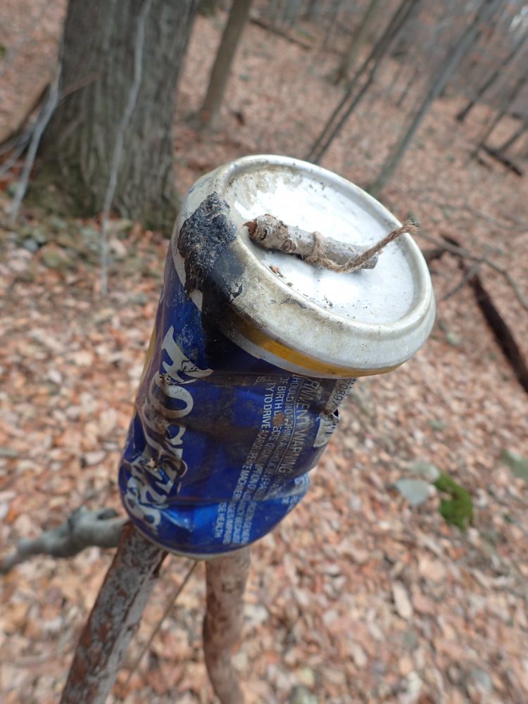 Make a hole in top of can to accommodate a cord that is attached to another stick for suspending the pot or kettle.