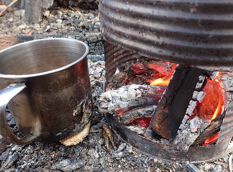 Coffee cups and some food can be warmed as stove dies down due to radiant heat and glowing coals. Fire is easy to start up again when more fuel is added.