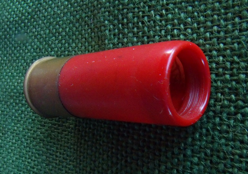 This 12-gauge slug shell has primer, powder charge, wad, and roll crimp, but no slug.