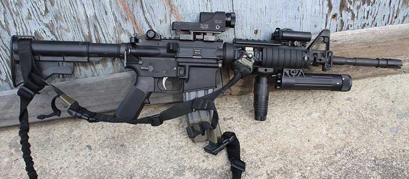 Author’s clone of his initial issue 1998 SOPMOD Block I carbine. AR is outfitted with Trijicon Reflex Sight, authentic SOPMOD I CVL-100 PEQ-5 laser, Insight VLI, Knight’s Armament RAS rail with VFG, back-up rear sight, and sling mount.