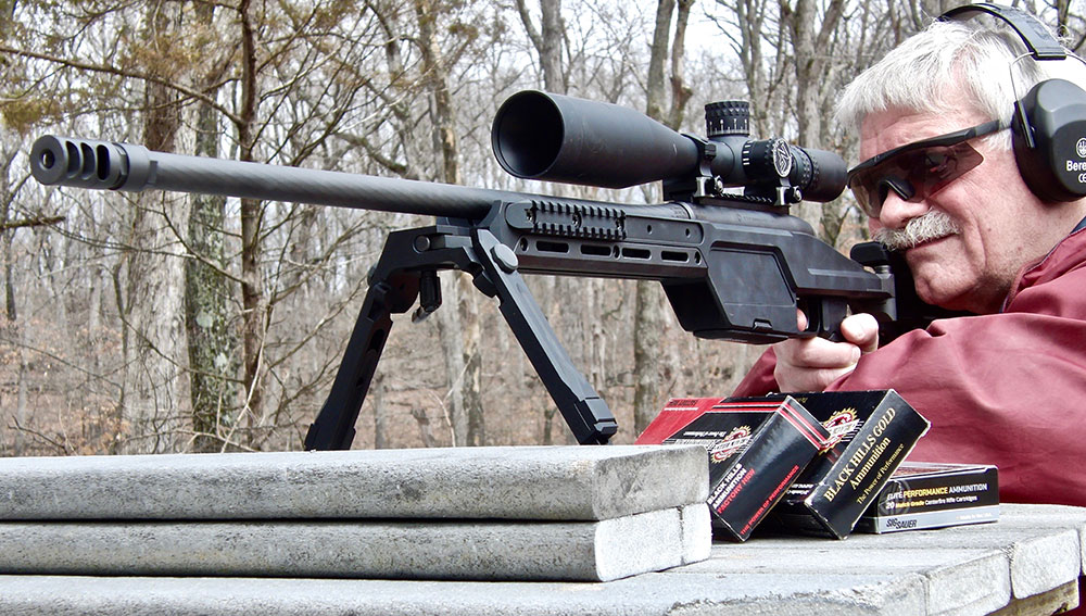 Thompson shoots SSG 08 .300 Win Mag from the bench.