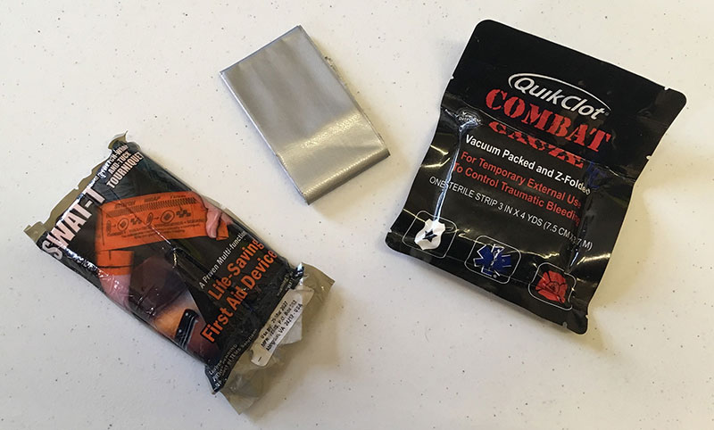 Three items in author’s travel trauma kit: SWAT-T tourniquet, QuikClot Combat Gauze, and duct tape.