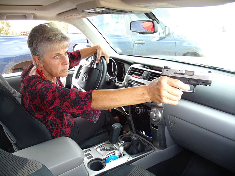 Practicing potential responses to a threat may increase your effectiveness. Author practices addressing a threat through passenger window of her vehicle.