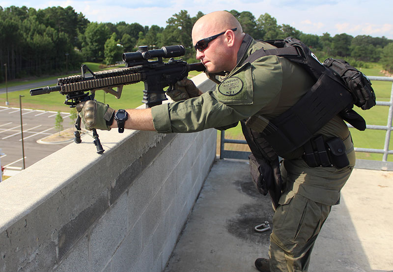 Due to narrow width of ledge, traversing left or right is limited. Even with bipods set on their shortest setting, this officer is still exposed above the wall.