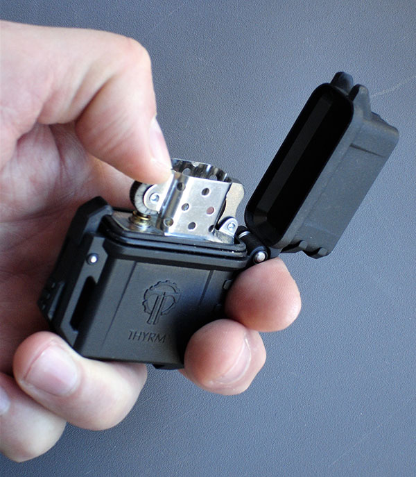 Thyrm PyroVault accepts standard Zippo-style lighter inserts, including both fluid and butane direct-flame models. It is O-ring sealed for weather resistance and to minimize evaporation.