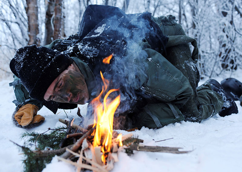 U.S. Air Force officer builds fire to help combat frostbite and hypothermia during SERE exercise. Knowing how to build a fire is one of the most important survival skills. Photo: U.S Air Force