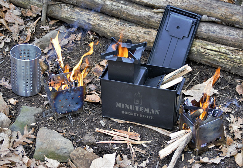 Left to right: Siege Stove with Ikea cutlery container and proprietary collapsible stove, Minuteman Rocket Stove, and Überleben Stöker Flatpack Stove. Each stove is fed in completely different ways, and each feed method has positives and negatives, depending on needs.