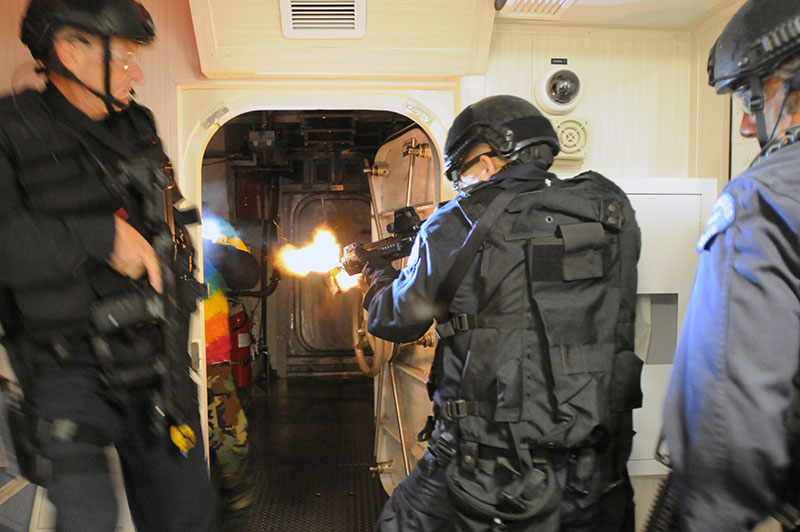 Los Angeles Police Department D Platoon (SWAT) team members breach room and engage hostile targets in training exercise focused on visit, board, search, and seizure tactics aboard maritime vessels. D Platoon was one of first U.S. law enforcement tactical teams to employ NFDDs. Photo: U.S. Navy photo by Mass Communication Specialist 3rd Class Kristopher Kirsop / Released