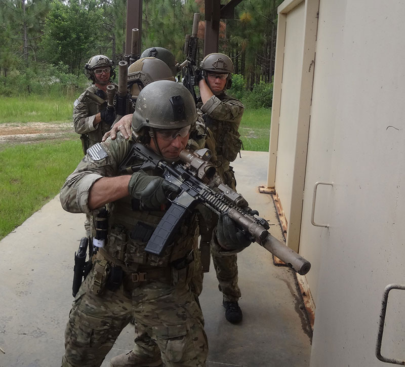 Five-man team makes entry. Instead of rushing in hoping number three and four man pick up center threats, number one man takes a split second to pie off the door, looking for any threats he can engage prior to entry.