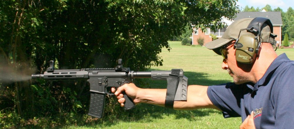 Ken Trice demos use of arm brace when shooting SAINT as a pistol. Extra weight makes steady hold a challenge, but it can be done. Recoil is heavier than 5.56mm, but not dramatically so.