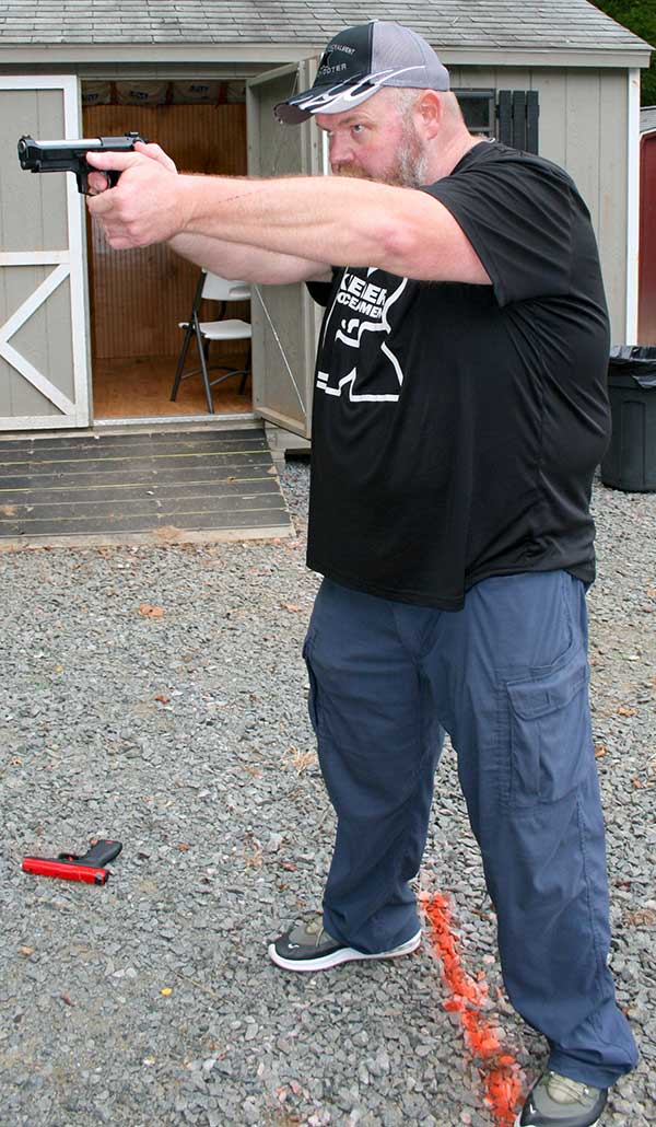 Keepers drives gun straight to the target while prepping his double-action trigger. Arms are fully extended, but elbows are locked and relaxed.