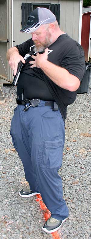 Body bends to rear and pistol is looked into holster with trigger finger in register.