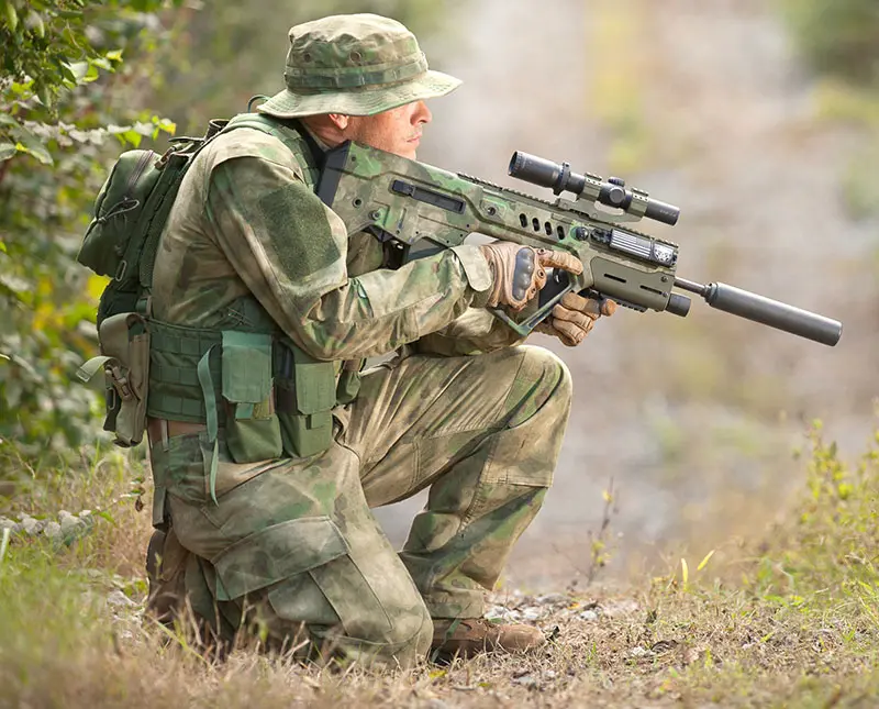 A-TACS Tavor 21 suppressed and scoped to fulfill limited sniper role. Aftermarket foregrip houses powerful white light.