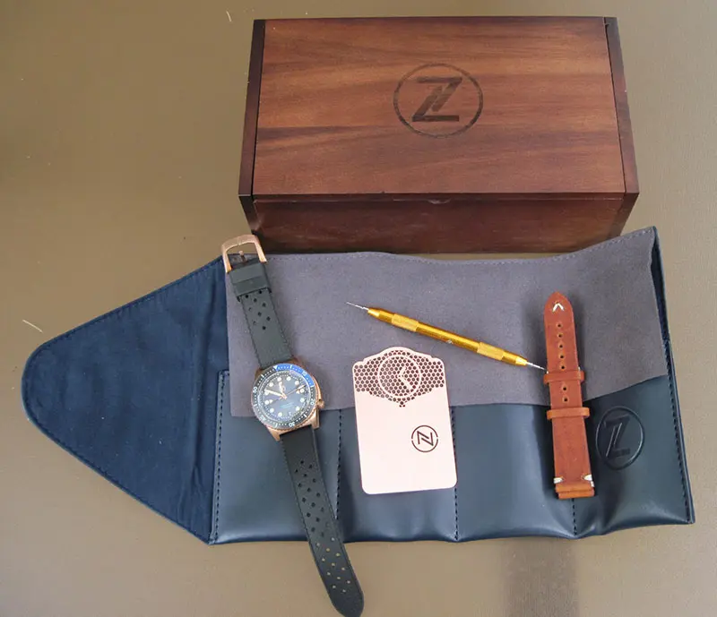 Zelos Mako Bronze Diver watch includes leather strap, strap-changing tool, warranty card, leather watch roll, and wooden box.