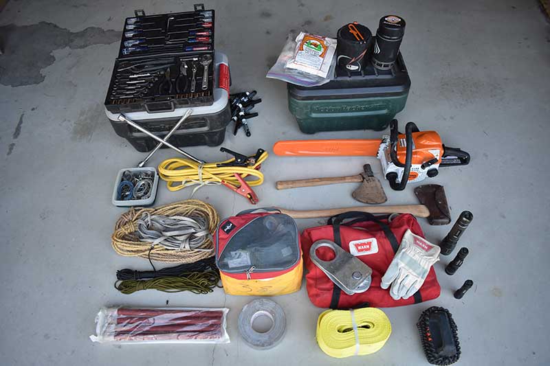 Spare parts, oil, chainsaw, ax, tools, tow strap, stove and food, lights, and winch kit—all secured yet easily accessible.