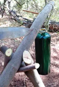 Author-made-tripod-of-green-willow-consisting-of-two-forked-sticks-holding-up-a-support-pole-for-hanging-cookware-over-a-small-fire