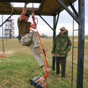 Competitor-climbs-rope-ladder-as-TJ-Piling-loo-ks-on