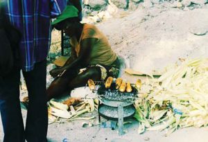 Days-after-2011-earthquake,-woman-cooks-on-charcoal-grill-in-Haiti