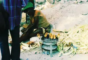 Days-after-2011-earthquake,-woman-cooks-on-charcoal-grill-in-Haiti