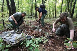 Survival-school-students-gather-debris-in-their-ponchos-to-be-dumped-on-top-of-completed-“A”-frame