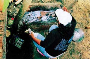 Woman-in-Amazon-jungle-cooks-a-meal-for-a-dozen-people-between-two-logs