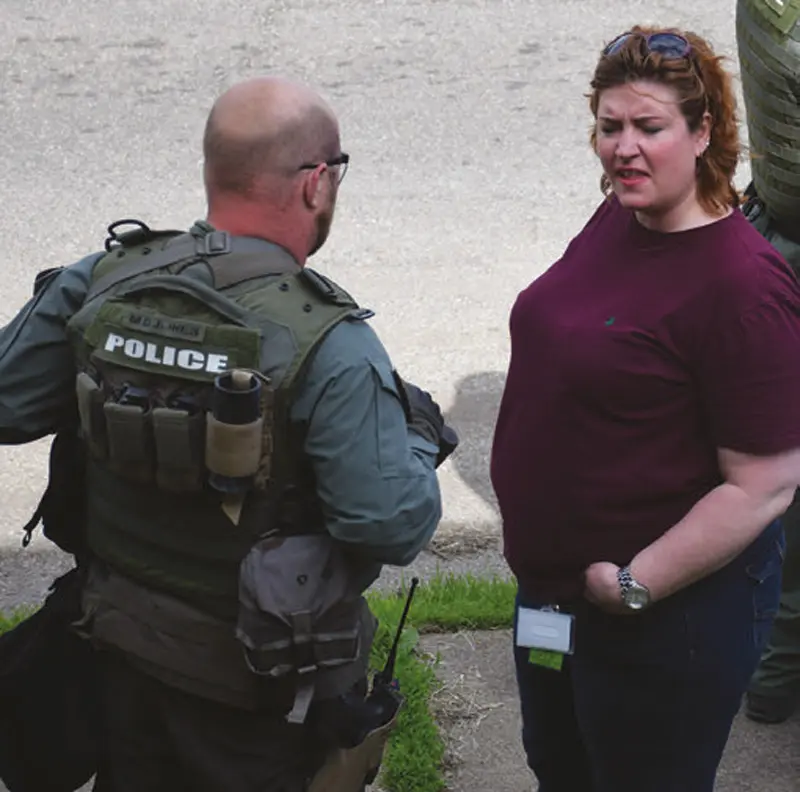 At-scene-of-warrant-execution,-prosecutor-Jennifer-Arnold-talks-with-SRT-member-M.D.-(Doc)-Jones