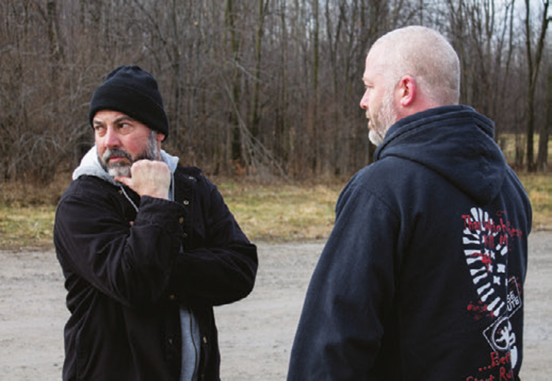 Bad-guy-holds-his-hands-high-in-preparation-to-strike-and-scans-the-area-for-witnesses-or-backup