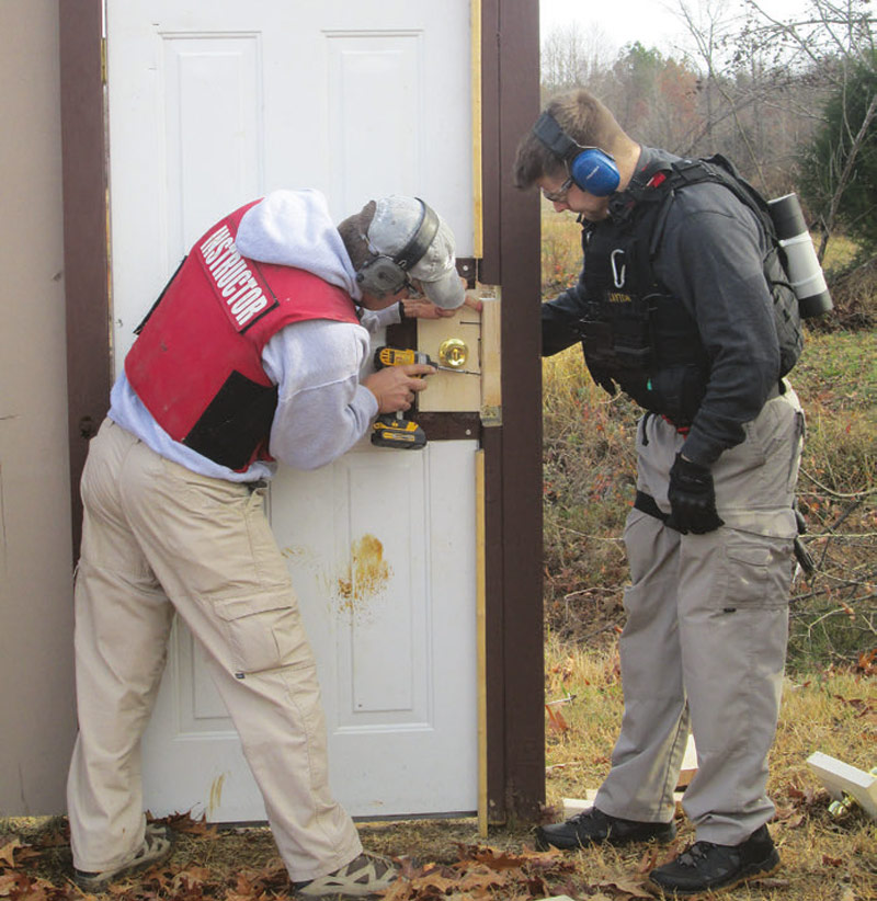 Instructor-candidate-learns-how-to-replace-lock-and-strike-palter-inserts-on-door