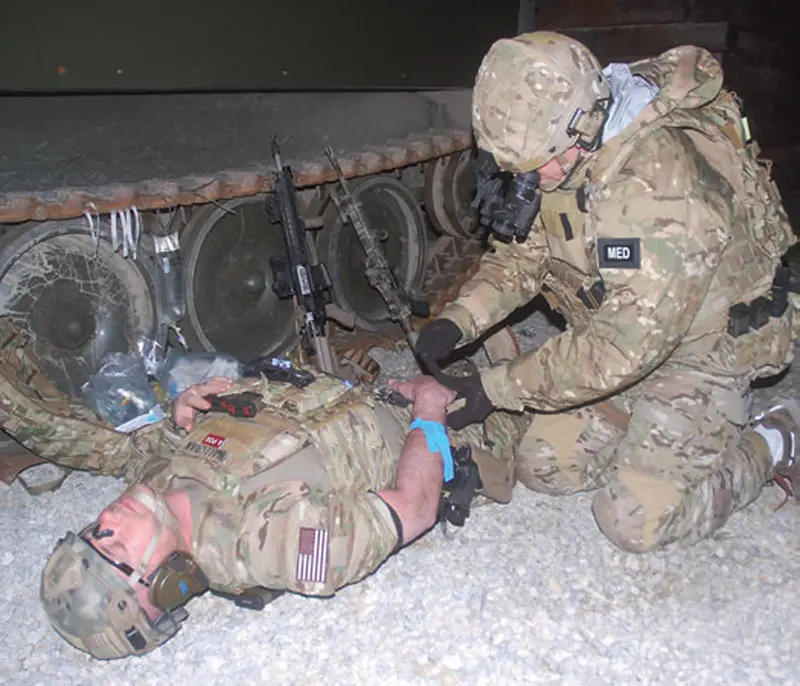 Medic-prepares-to-place-IV-in-casualty’s-hand-under-night-vision-with-PVS-14s-and-Battleview