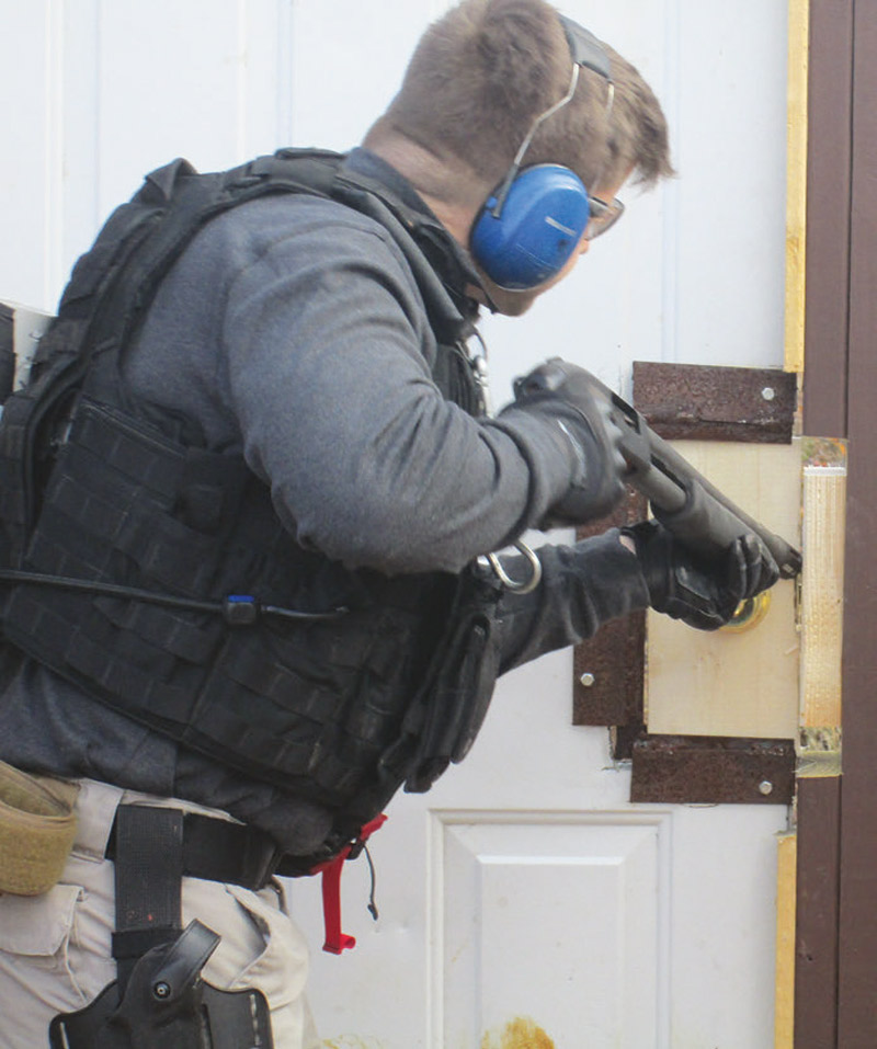 Student-performs-ballistic-(shotgun)-breach-on-door-faзade-using-replaceable-dowel-rods