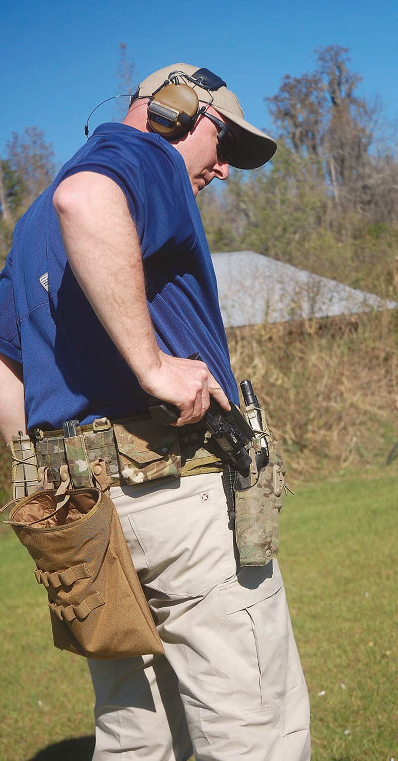 Wade-Lynton-of-the-Evans-Group-glances-at-his-holster-to-ensure-the-pistol-goes-in-smoothly