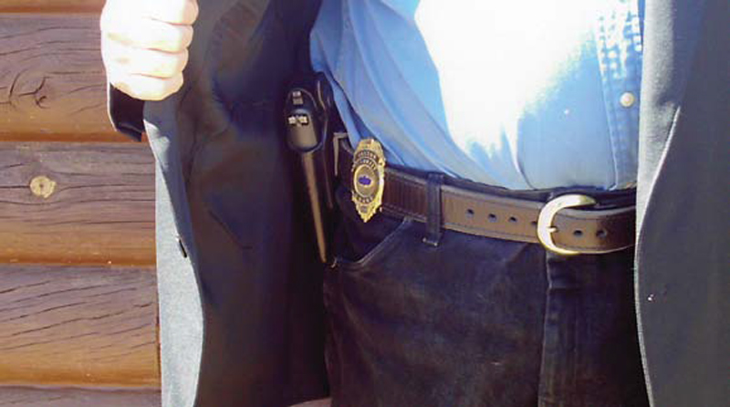 Holstered-gun-with-bright,-shiny-badge