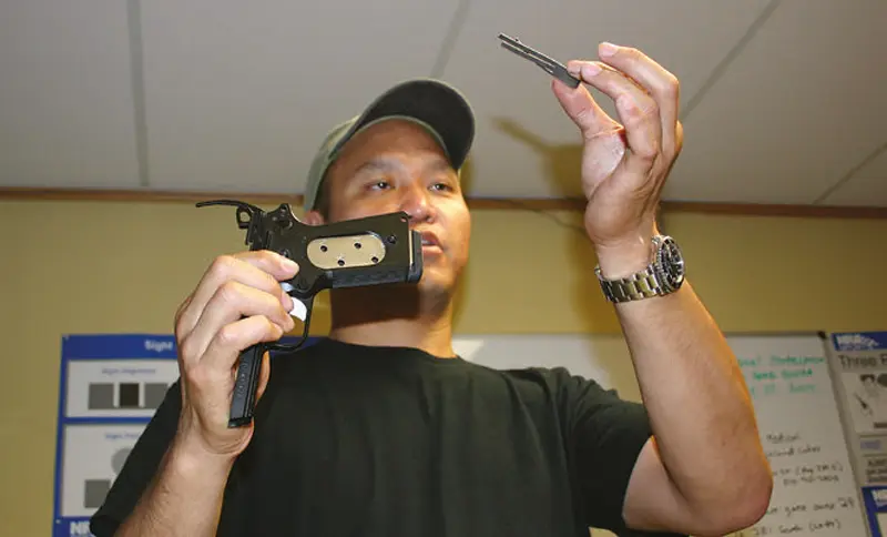Tim-Lau-demonstrates-reassembly-trick-for-putting-the-sear-spring-back-in-pistol
