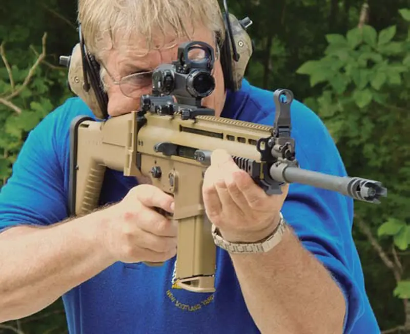 Thompson-shoots-SCAR-L-with-Leupold-HAMR-at-100-yard-plates-offhand-using-CM-R-reticle